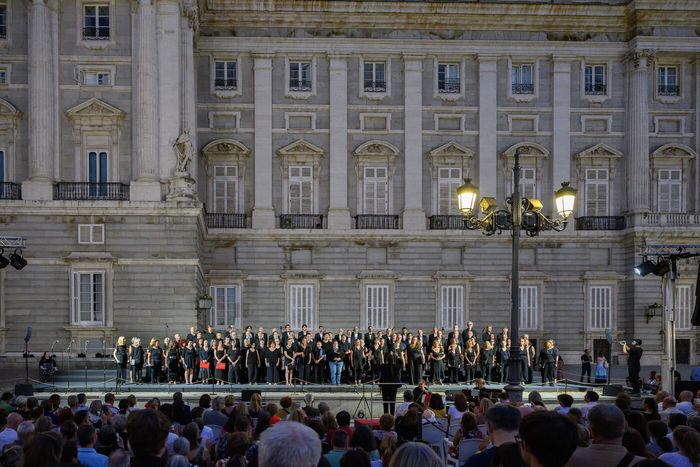 Los numerosos miembros del coro vestidos de negro frente al Palacio Real.