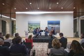 Evento en la Embajada de Alemania con un cuarteto de cuerdas tocando en un escenario frente a una audiencia, en una sala moderna con obras de arte en la pared.