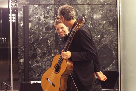 Katharina Gruber y Christian Gruber mirandose sonriendo en el escanrio del Pabellón Mies van der Rohe