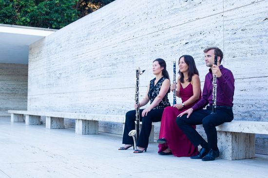 El trío de clarinete tocando en el Pabellón Mies, sonriendo